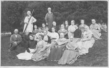 SA0148 - Photo shows North Family group. Trustee Levi Shaw at left with rake and hoe. Catherine Allen is fourth from left in last row seated next to Anna Case (in glasses). Leila Sarah Taylor is second from left in second row. Ad for other views on the ba